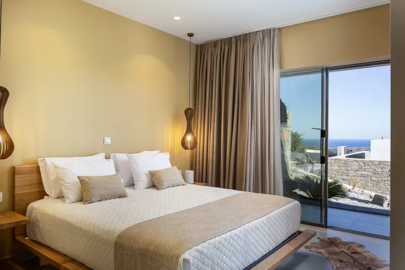 Bedroom with double bed and terrace door with a view of the sea