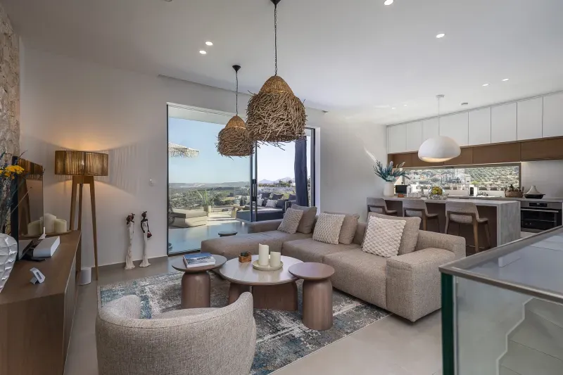 Open-plan living area with sofa, kitchen and view of the terrace