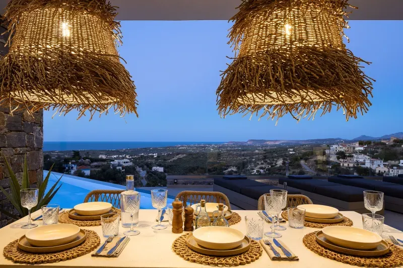 Set table on the covered terrace overlooking the pool and the sea
